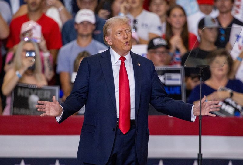 © Reuters. Republican presidential nominee and former U.S. President Donald Trump gestures during a rally with his vice presidential running mate U.S. Senator JD Vance in St. Cloud, Minnesota, U.S., July 27, 2024. REUTERS/Carlos Osorio