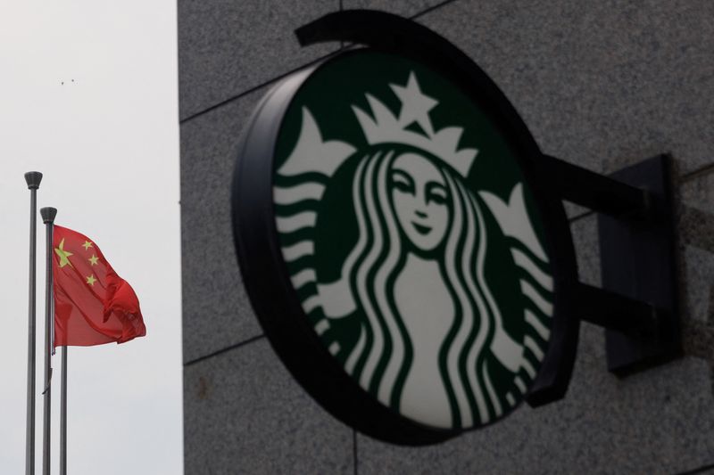 &copy; Reuters. FILE PHOTO: The Chinese flag flies near the Starbucks logo outside a cafe of the coffee chain in Beijing, China, August 3, 2022. REUTERS/Thomas Peter/File Photo