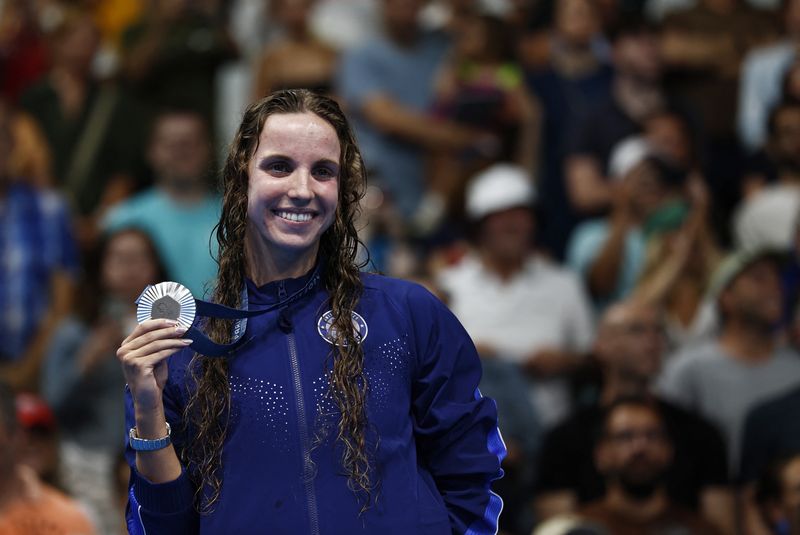 © Reuters. Paris 2024 Olympics - Swimming - Women's 100m Backstroke Victory Ceremony - Paris La Defense Arena, Nanterre, France - July 30, 2024. Silver medallist Regan Smith of United States celebrates on the podium with her medal. REUTERS/Clodagh Kilcoyne