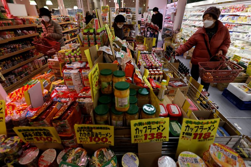 © Reuters. FILE PHOTO: Shoppers check food items at a supermarket in Tokyo, Japan January 20, 2023. REUTERS/Issei Kato/File Photo