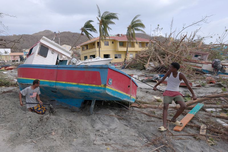 &copy; Reuters. FILE PHOTO: A man digs out a stranded boat after Hurricane Beryl passed the island of Petite Martinique, Grenada July 2, 2024.  REUTERS/Arthur Daniel/File Photo