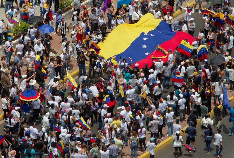 © Reuters. People carry Venezuela's national flag to protest the election results that awarded Venezuela's President Nicolas Maduro with a third term, in Maracaibo, Venezuela July 30, 2024. REUTERS/Isaac Urrutia