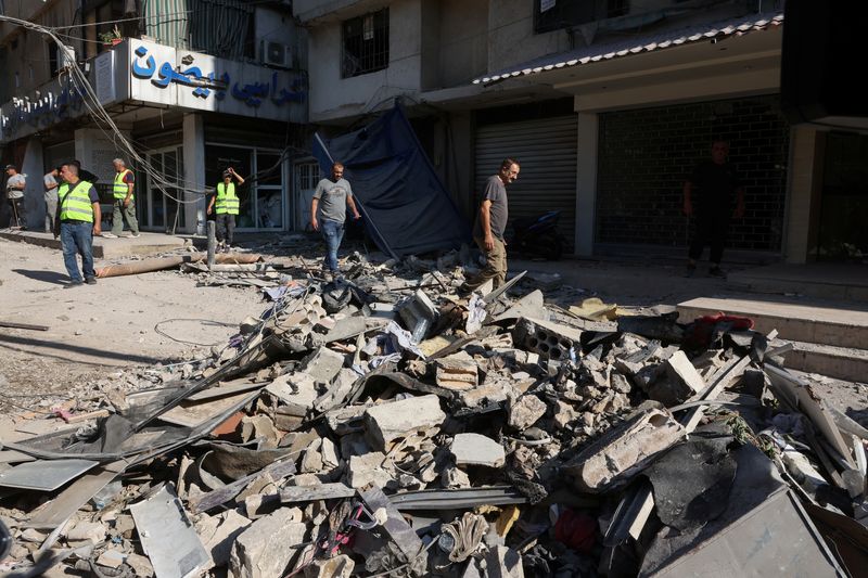 © Reuters. People walk on the rubble of a damaged site the day after an Israeli strike, in Beirut's southern suburbs, Lebanon July 31, 2024. REUTERS/Mohamed Azakir