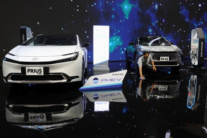 © Reuters. A man wipes the floor near the Toyota Prius PHEV and Toyota BZ4X during the Indonesia International Auto Show in Tangerang, Indonesia, July 18, 2024. REUTERS/Ajeng Dinar Ulfiana