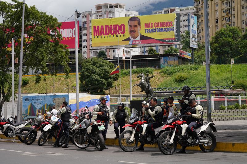 &copy; Reuters. Police officers stand near a hoarding with an image of Venezuela's President Nicolas Maduro, in Caracas, Venezuela, July 31, 2024. REUTERS/Alexandre Meneghini