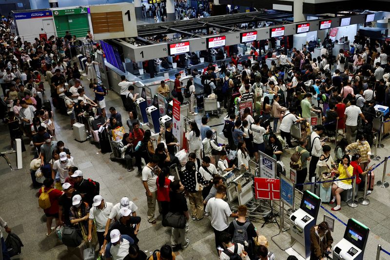 © Reuters. FILE PHOTO: Air Asia passengers queue at counters inside Don Mueang International Airport Terminal 1 amid the global outage that disrupted the airline's operations, in Bangkok, Thailand, on July 19, 2024. REUTERS/Chalinee Thirasupa//File Photo