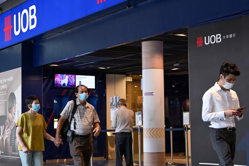 © Reuters. FILE PHOTO: People walk past a United Overseas Bank branch in Singapore March 31, 2022. REUTERS/Caroline Chia/File Photo