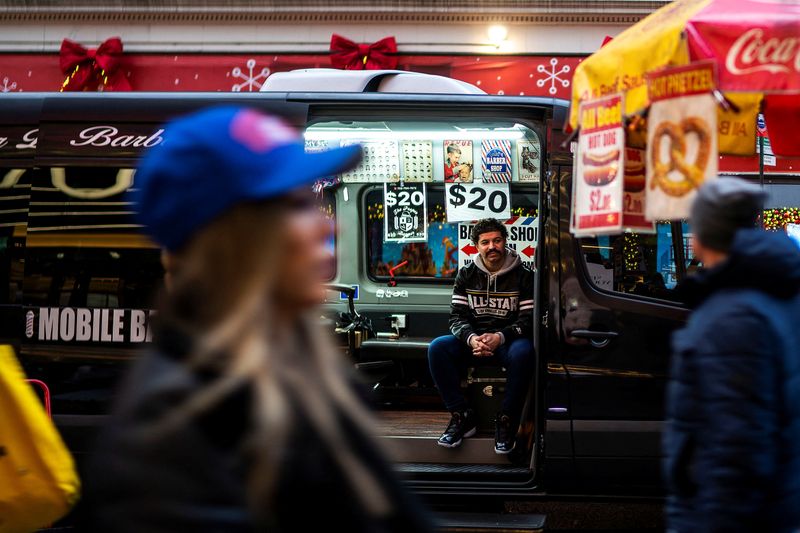 © Reuters. FILE PHOTO: An independent barber waits for customers on his van in a local street in New York, U.S., December 25, 2023. REUTERS/Eduardo Munoz