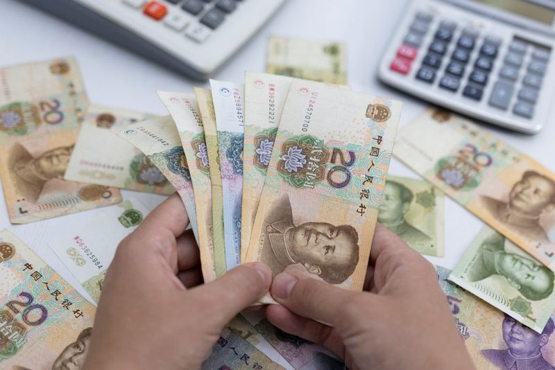 &copy; Reuters. Woman holds Chinese Yuan banknotes in this illustration taken May 30, 2022. REUTERS/Dado Ruvic/Illustration/File Photo