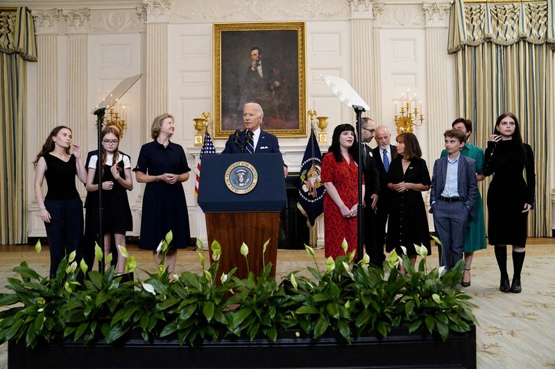 © Reuters. Paul Whelan's sister, Elizabeth Whelan, Alsu Kurmasheva's relatives Pavel Butorin, Bibi Butorin and Miriam Butorin, and Evan Gershkovich's relatives Mikhail Gershkovich, Ella Milman Danielle Gershkovich and Anthony Huczek flank U.S. President Joe Biden as he speaks about the release of Americans detained in Russia during brief remarks from the White House in Washington, U.S., August 1, 2024. REUTERS/Nathan Howard