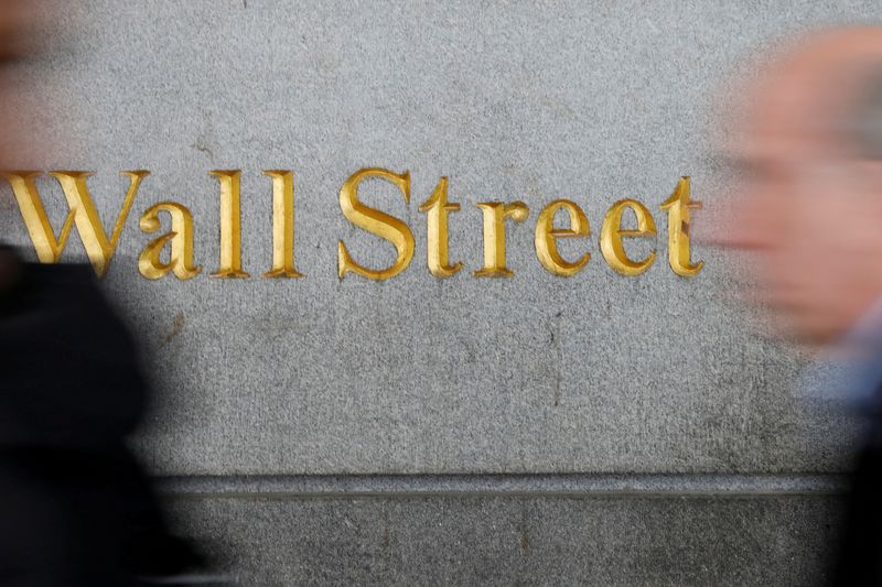 © Reuters. FILE PHOTO: People walk by a Wall Street sign close to the New York Stock Exchange (NYSE) in New York, U.S., April 2, 2018. REUTERS/Shannon Stapleton/File Photo