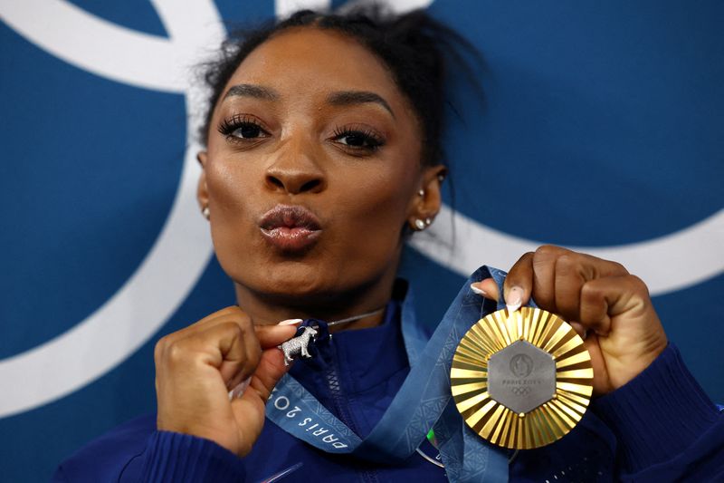 © Reuters. Paris 2024 Olympics - Artistic Gymnastics - Women's All-Around Victory Ceremony - Bercy Arena, Paris, France - August 01, 2024. Gold medallist Simone Biles of United States celebrates with her medal. REUTERS/Hannah Mckay    