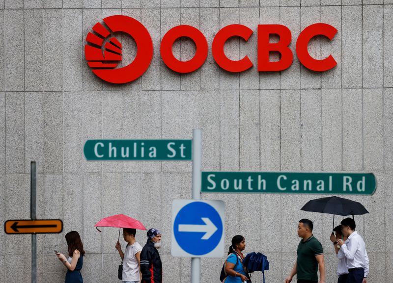 &copy; Reuters. FILE PHOTO: People pass an OCBC Bank signage in Singapore July 11, 2023. REUTERS/Edgar Su/File Photo