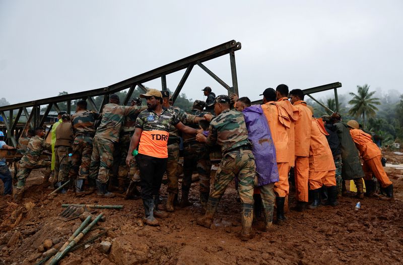 © Reuters. Army personnel and volunteers lift a portion of a bridge during its re-construction, after landslides hit Chooralmala in Wayanad district in the southern state of Kerala, India, August 1, 2024. REUTERS/Francis Mascarenhas