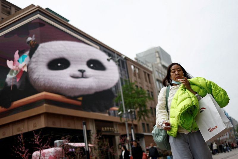 © Reuters. FILE PHOTO: A woman walks at a shopping street in Beijing, China April 10, 2024. REUTERS/Tingshu Wang/File Photo