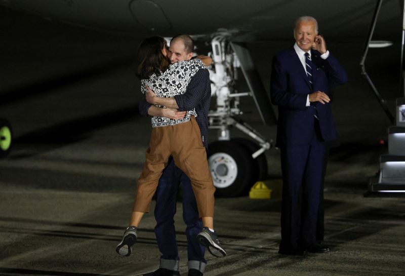 © Reuters. U.S. President Joe Biden looks on as Evan Gershkovich who was released from detention in Russia, is greeted by his mother Ella Milman, upon his arrival at Joint Base Andrews in Maryland, U.S., August 1, 2024. REUTERS/Kevin Mohatt