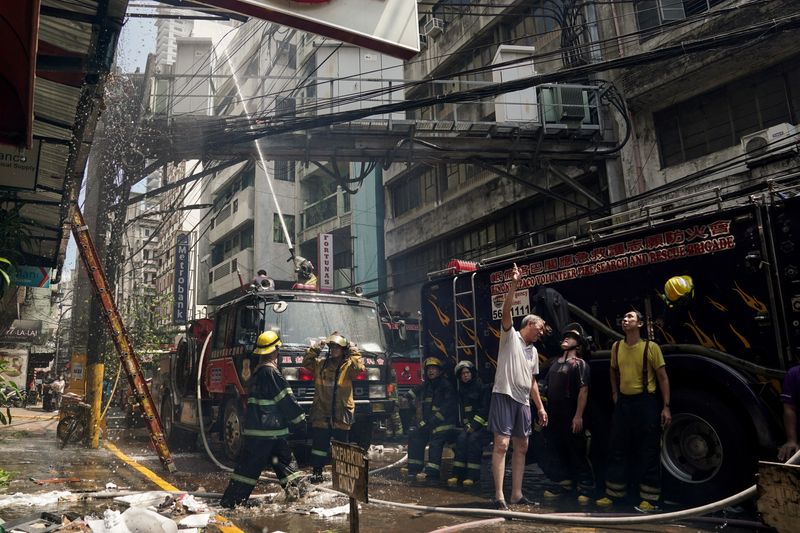 © Reuters. Firemen extinguish a fire at a building in Manila, Philippines, August 2, 2024. REUTERS/Lisa Marie David