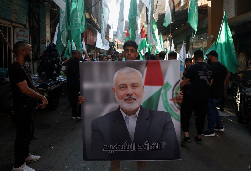 © Reuters. FILE PHOTO: A Palestinian carries a picture of late Hamas leader Ismail Haniyeh, who was killed in Iran, during a march to condemn his killing, at Burj al-Barajneh Palestinian refugee camp in Beirut, Lebanon July 31, 2024. REUTERS/Mohamed Azakir/File Photo