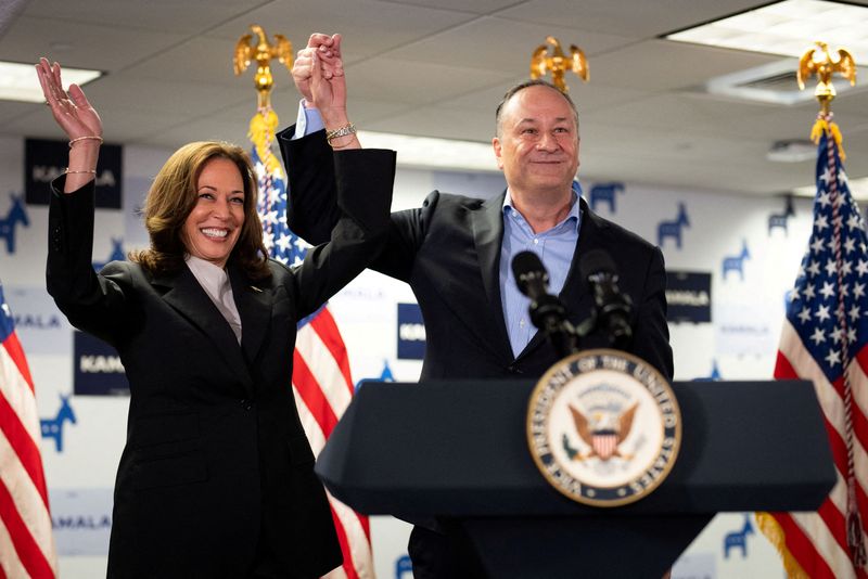 &copy; Reuters. FILE PHOTO: U.S. Vice President Kamala Harris and second gentleman Douglas Emhoff gesture at Kamala's Presidential Campaign headquarters in Wilmington, DE, U.S.,  July 22, 2024.  Erin Schaff/Pool via REUTERS/File Photo