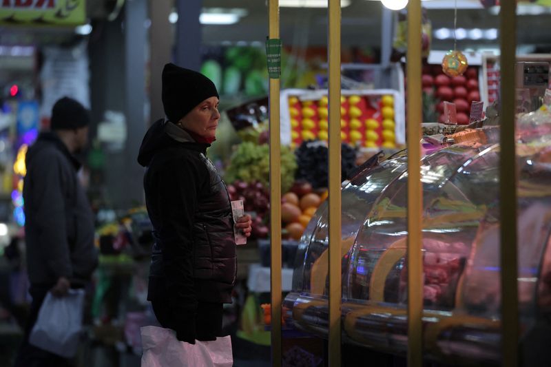 &copy; Reuters. A customer holds a Russian rouble banknote while looking at foodstuffs at a market in Saint Petersburg, Russia, November 10, 2023. REUTERS/Anton Vaganov/ File Photo