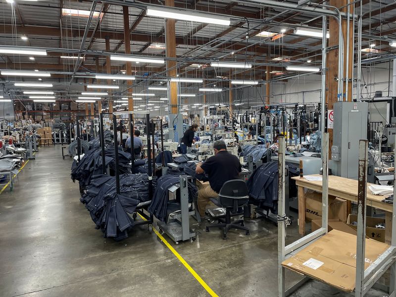 © Reuters. FILE PHOTO: People work at Saitex's factory, which experiments with new robots to cut the cost of making blue jeans, in Los Angeles, California, U.S. September 21, 2022. REUTERS/Timothy Aeppel/File Photo