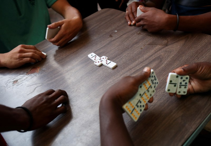 © Reuters. FILE PHOTO: Migrants, mostly from Haiti, play dominoes at Cafemin shelter as they wait for a permit that would allow them to continue their journey to the border between Mexico and the United States, in Mexico City, Mexico May 18, 2023. REUTERS/Henry Romero/File Photo