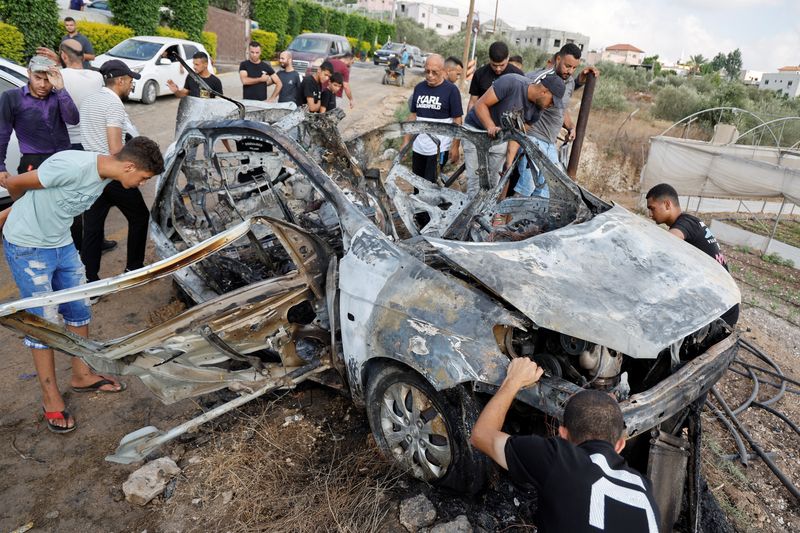 © Reuters. Palestinians inspect a vehicle damaged in an Israeli airstrike, in Zeita, near Tulkarm, in the Israeli-occupied West Bank, August 3, 2024. REUTERS/Raneen Sawafta