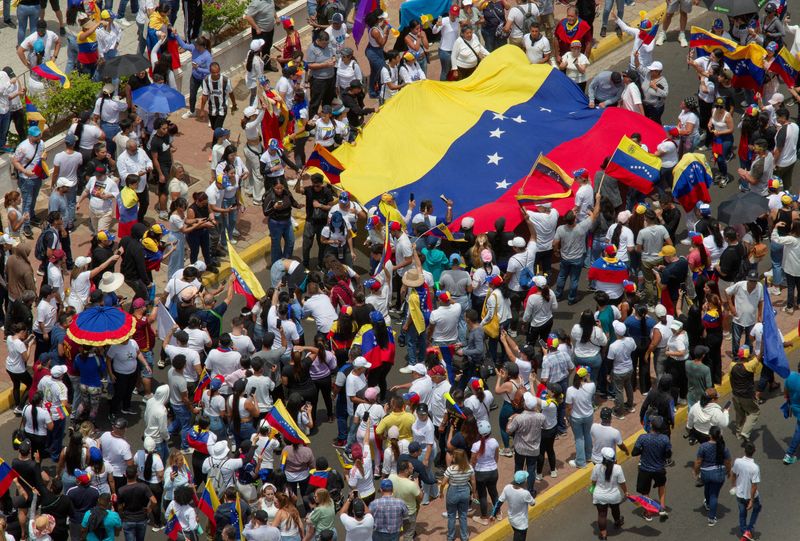 © Reuters. FILE PHOTO: People carry Venezuela's national flag to protest the election results that awarded Venezuela's President Nicolas Maduro with a third term, in Maracaibo, Venezuela July 30, 2024. REUTERS/Isaac Urrutia/File Photo