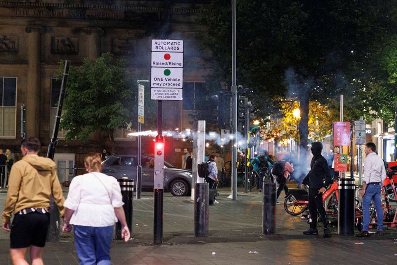 © Reuters. Protestors throw fireworks as the riots continue into the night in Liverpool, Britain, August 3, 2024. REUTERS/ Belinda Jiao