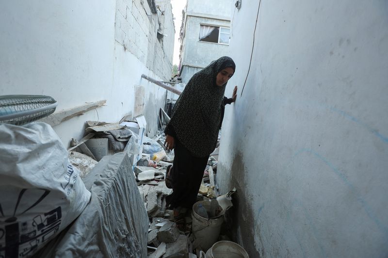 © Reuters. A Palestinian woman inspects the site of an Israeli strike on a house, amid the Israel-Hamas conflict, in Deir Al-Balah in the central Gaza Strip, August 4, 2024. REUTERS/Ramadan Abed