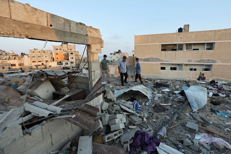 ©Reuters.  Palestinians inspect the site of an Israeli attack on a house in Deir al-Balah, central Gaza, on August 4, 2024, during the conflict between Israel and Hamas.