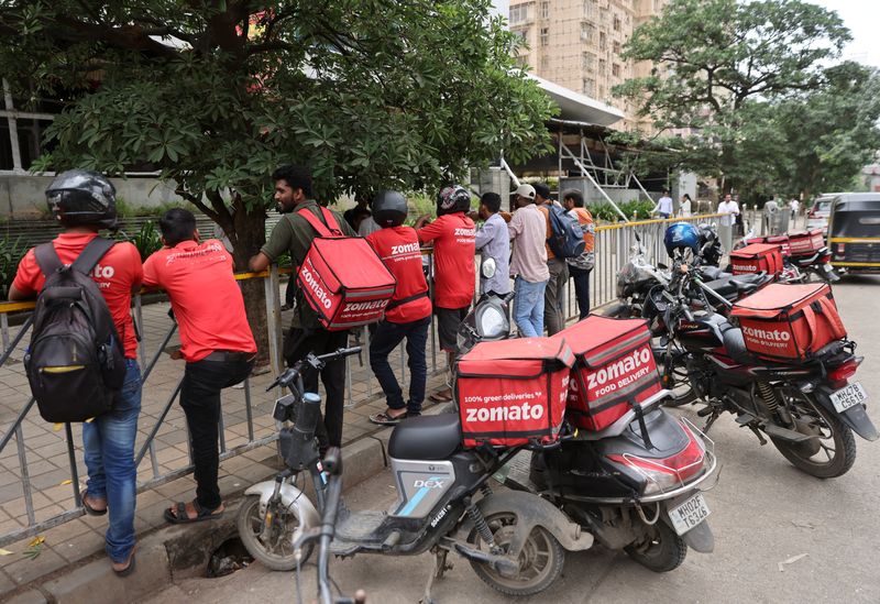 © Reuters. FILE PHOTO: Gig workers wait in line to collect their delivery order outside a mall in Mumbai, India, August 10, 2023. REUTERS/Francis Mascarenhas/File Photo