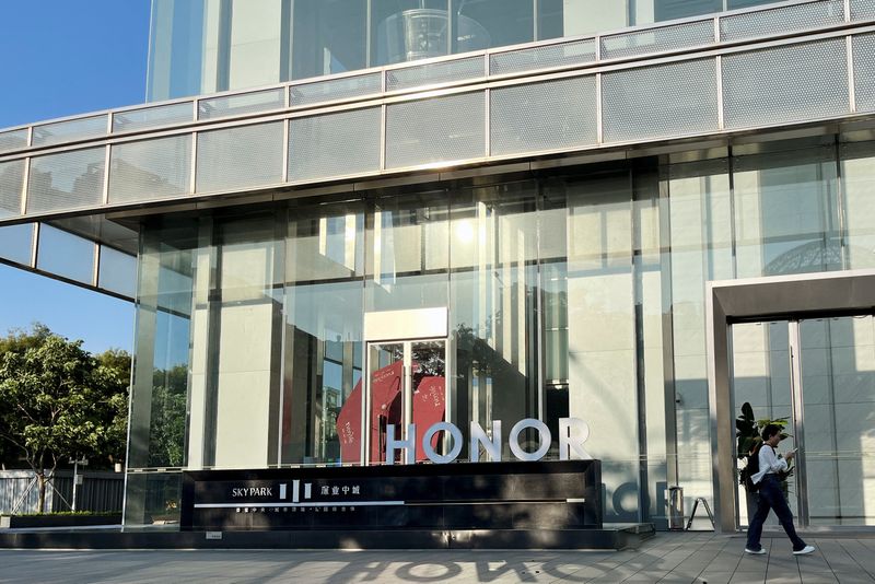 &copy; Reuters. A woman walks past an Honor sign at the handset maker's headquarters in Shenzhen, Guangdong province, China August 4, 2024. REUTERS/David Kirton