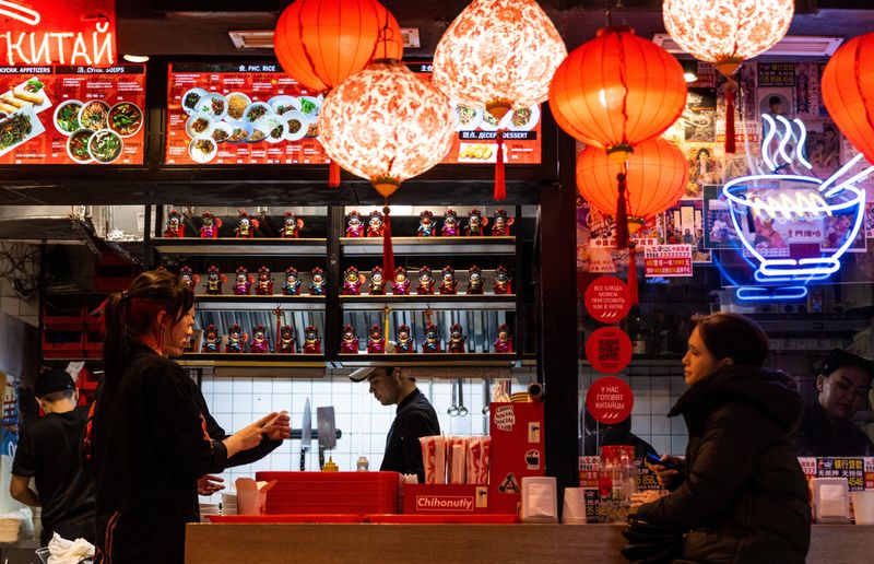 © Reuters. FILE PHOTO: A woman looks on as she waits at a Chinese restaurant in Moscow, Russia March 13, 2023. REUTERS/Maxim Shemetov/File Photo