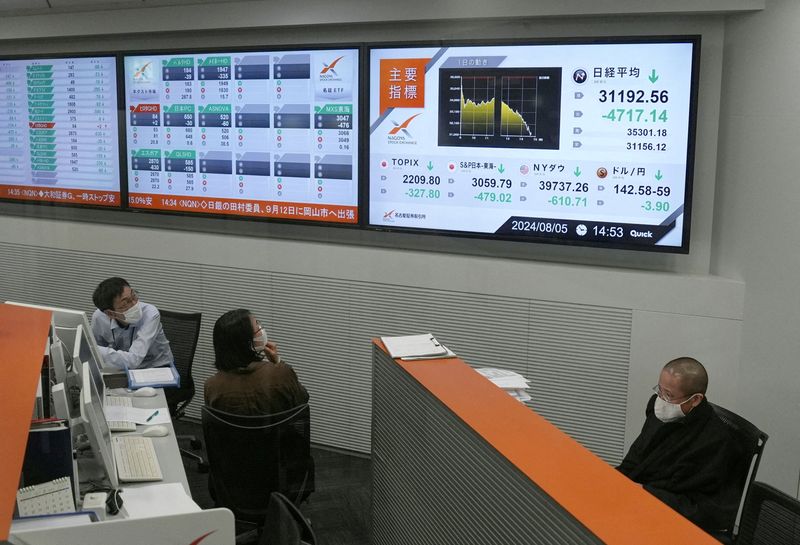 &copy; Reuters. Employees look on the monitors displaying Japan's Nikkei share average, which has had a record breaking-drop in the closing price, at Nagoya Stock Exchange in Nagoya, Japan, August 5, 2024, in this photo taken by Kyodo. Mandatory credit Kyodo/via REUTERS 