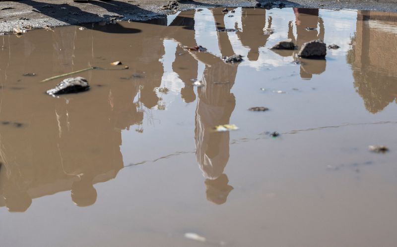 © Reuters. Displaced Congolese people are reflected on a puddle, at the Muchacha primary school, where they live after recently fleeing from their Shasha village following clashes between M23 rebels and the Armed Forces of the Democratic Republic of the Congo (FARDC) in Sake, the Democratic Republic of Congo February 6, 2024. REUTERS/Arlette Bashizi