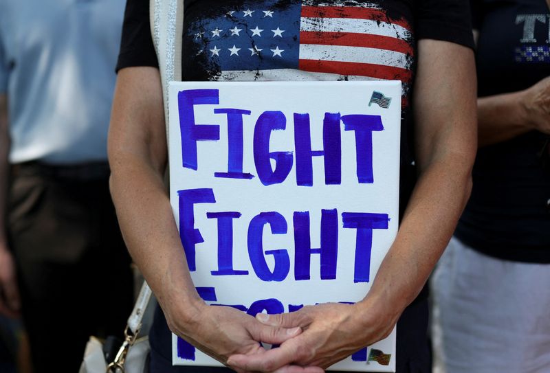 &copy; Reuters. FILE PHOTO: A supporter of former U.S. President Donald Trump holds a placard as he and others attend a prayer vigil hosted by Turning Point Action near the venue for the Republican National Convention (RNC), at Zeidler Union Square in Milwaukee, Wisconsi