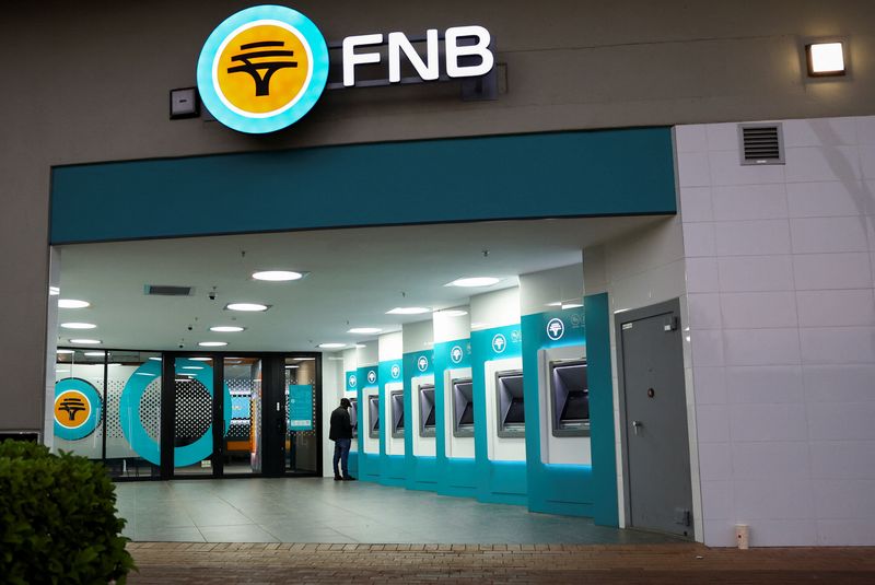 © Reuters. FILE PHOTO: A customer uses an ATM outside a branch of South Africa's First National Bank (FNB) at a mall in Soweto, South Africa, December 13, 2023. REUTERS/Siphiwe Sibeko/File Photo