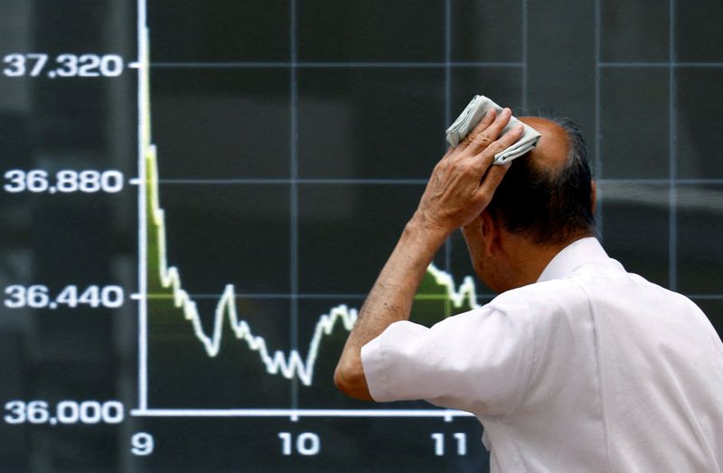 © Reuters. FILE PHOTO: A man wipes his sweat as he walks in front of an electronic screen displaying the graph showing today's movements of Japan's Nikkei share average outside a brokerage in Tokyo, Japan August 2, 2024. REUTERS/Issei Kato/File Photo