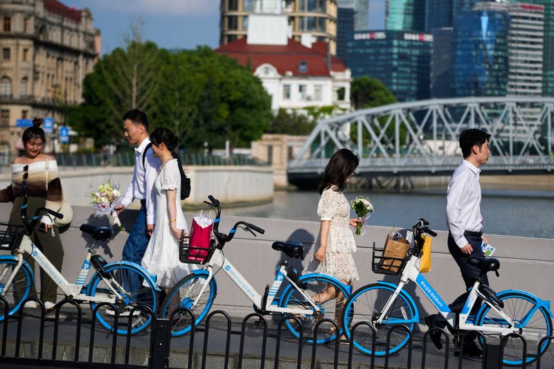 &copy; Reuters. FILE PHOTO: Couples prepare to get their photo taken during a wedding photography shoot on a street, in Shanghai, China September 6, 2023. REUTERS/Aly Song/File Photo