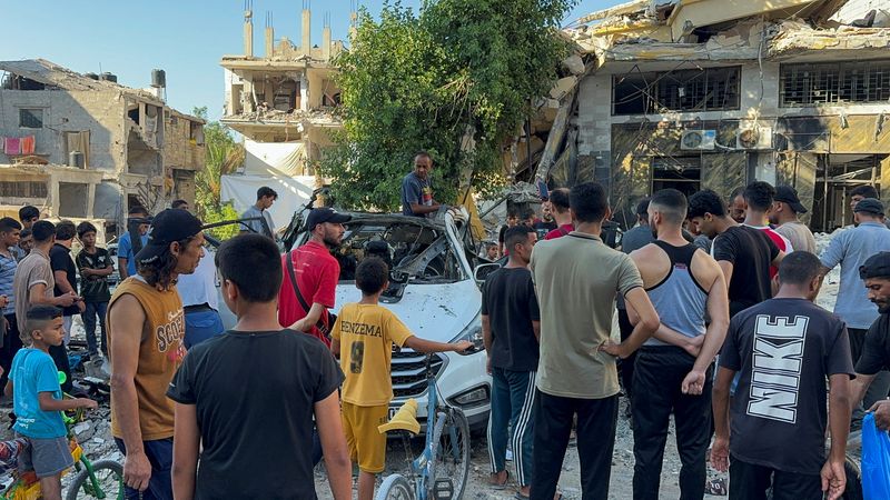 © Reuters. FILE PHOTO: Palestinians inspect a vehicle where Al Jazeera TV said its reporter Ismail al-Ghoul and cameraman Ramy El Rify were killed in an Israeli strike, in Gaza City July 31, 2024. REUTERS/Ayman Al Hassi/File Photo