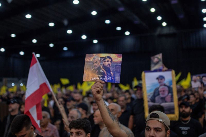 &copy; Reuters. A supporter holds a poster of late top commander of Iran's Quds Force Qassem Soleimani and late Hezbollah top commander Fuad Shukr before the speech of Hezbollah leader Sayyed Hassan Nasrallah, during a commemorative ceremony marking the first week since 