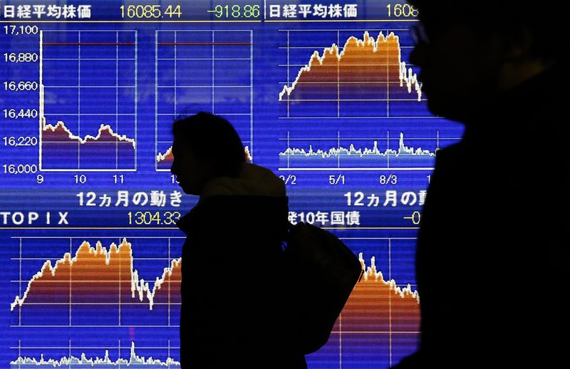 © Reuters. FILE PHOTO: Pedestrians walk past an electronic board showing the graphs of the recent fluctuations of Japan's Nikkei average outside a brokerage in Tokyo, Japan, February 9, 2016. A drop in bank shares kept European shares under pressure on Tuesday, after losses in Asian markets sent investors scurrying for safe havens. REUTERS/Yuya Shino/File Photo