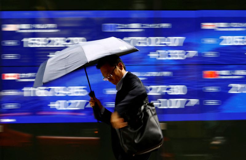 © Reuters. FILE PHOTO: A man walks past an electronic screen displaying the current Japanese Yen exchange rate against the U.S. dollar, Euro and other foreign currencies in Tokyo, Japan July 12, 2024, REUTERS/Issei Kato/File Photo