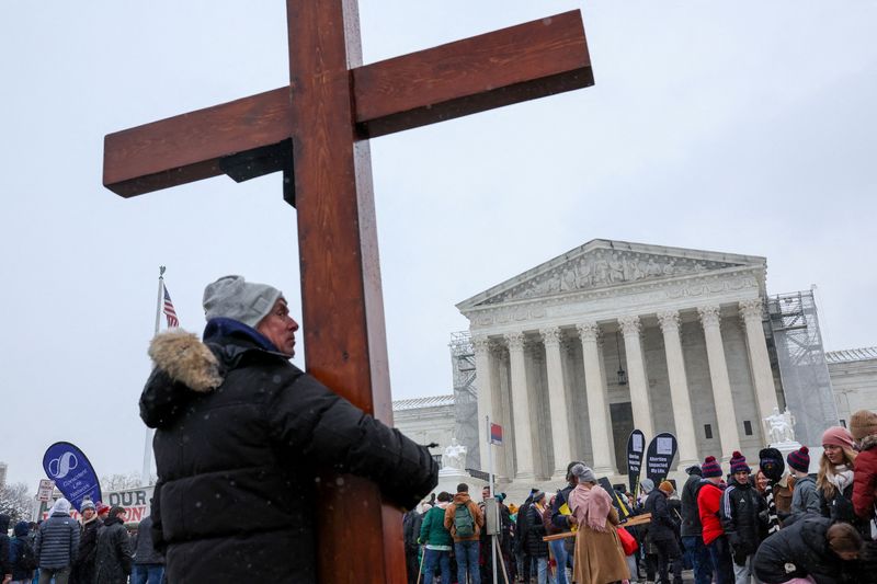 © Reuters. FILE PHOTO: Dan Beazley carries a cross as he participates in the annual 