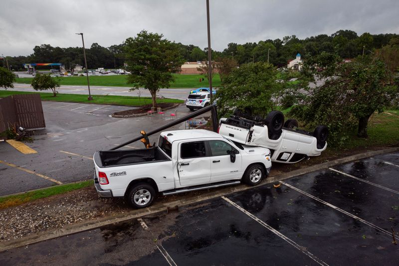 © Reuters. Damaged trucks are seen at a car dealer after a tornado hit the area as Tropical Storm Debby drifts in the East Coast, in Moncks Corner, South Carolina, U.S., August 7, 2024. REUTERS/Marco Bello