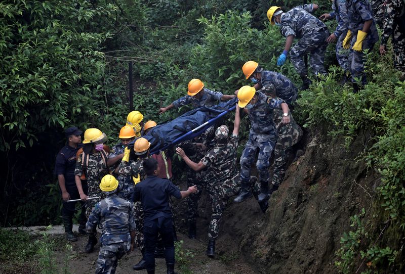 © Reuters. Security force personnel carry the body of a victim at the site of a helicopter crash on the outskirts of Kathmandu, Nepal, August 7, 2024. REUTERS/Navesh Chitrakar