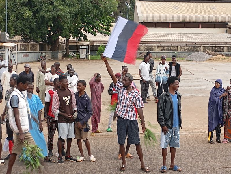 © Reuters. A man holds a Russian flag, as Nigerians protest in the streets during anti-government demonstrations against bad governance and economic hardship, in Kaduna state, Nigeria August 5, 2024. REUTERS/Stringer