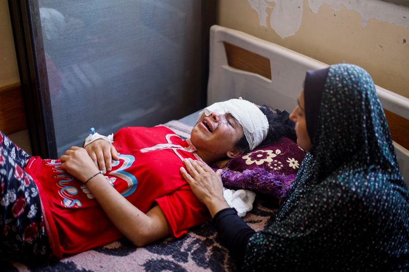 &copy; Reuters. Palestinian girl Maisa Al-Ghandour, who was wounded in an Israeli strike along with her two siblings and mother, is comforted by her mother as she cries on a bed at Nasser hospital, in Khan Younis in the southern Gaza Strip August 6, 2024. REUTERS/Mohamme