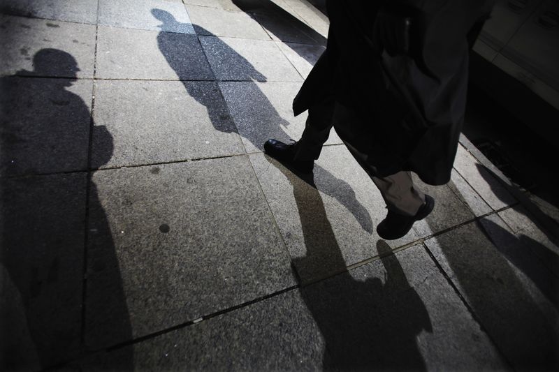 © Reuters. FILE PHOTO: Shadows are seen as a man walks down Bay Street in the financial district in Toronto, March 11, 2009. REUTERS/Mark Blinch/File Photo